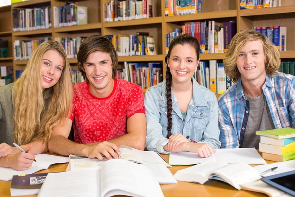 Estudantes universitários fazendo lição de casa na biblioteca — Fotografia de Stock