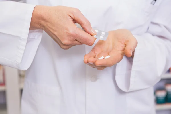 Mid section of pharmacist holding pills — Stock Photo, Image