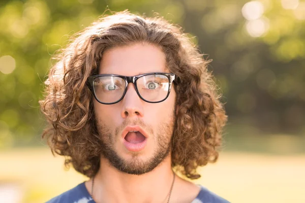 Gutaussehender Hipster sieht im Park überrascht aus — Stockfoto