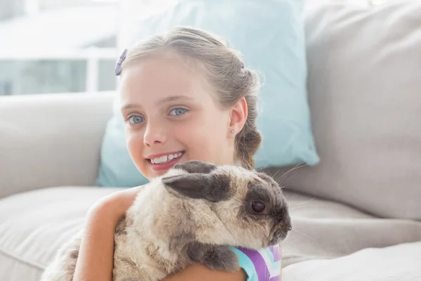 Dívka drží králík v obývacím pokoji — Stock fotografie