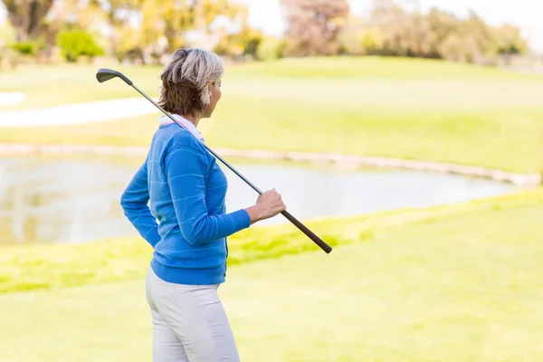 Golfista feminina de pé segurando seu clube — Fotografia de Stock