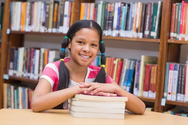 Söta elev titta på kameran i biblioteket — Stockfoto