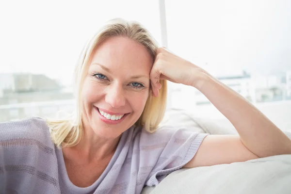 Femme souriante se détendre sur le canapé — Photo