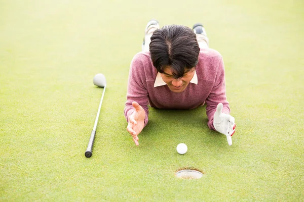 Golfer lying near golf ball — Stock Photo, Image