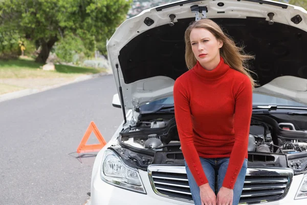 Geërgerd jonge vrouw naast haar auto uitgesplitst — Stockfoto