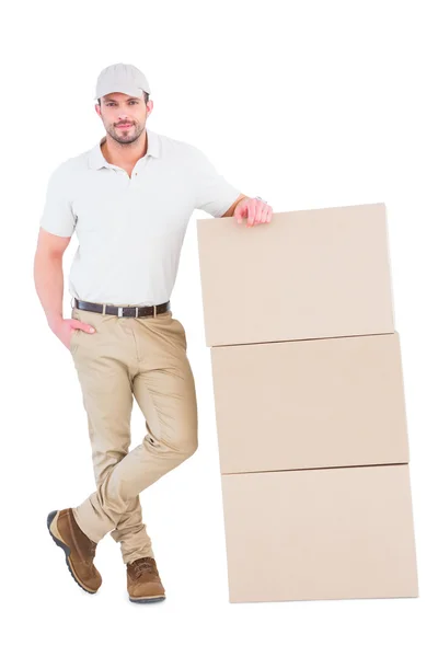 Entrega homem inclinado em caixas de papelão — Fotografia de Stock