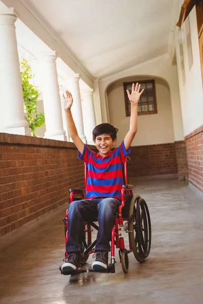 Chłopak na wózku inwalidzkim w szkolnym korytarzu — Zdjęcie stockowe