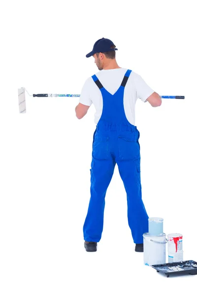 Handyman in overalls using paint roller — Stock Photo, Image