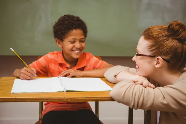 Leraar bijstaan jongen met huiswerk in klas — Stockfoto