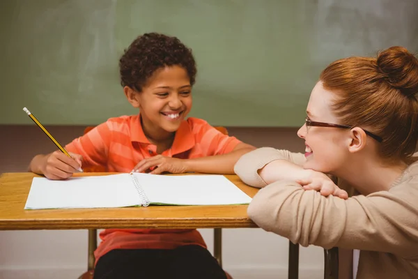 Teacher assisting boy with homework in classroom — Stock Photo, Image