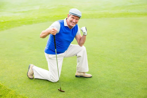 Golfista sorridente inginocchiato a mettere verde — Foto Stock