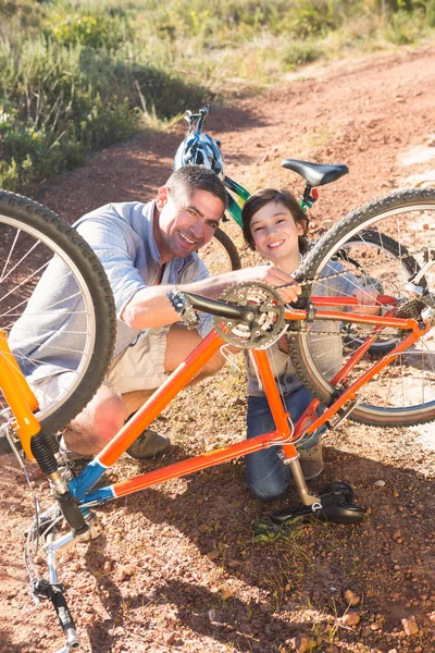 Padre e hijo reparando la bicicleta juntos —  Fotos de Stock