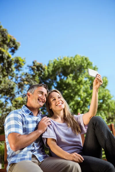 Couple relaxing in the park on bench — Stock Photo, Image
