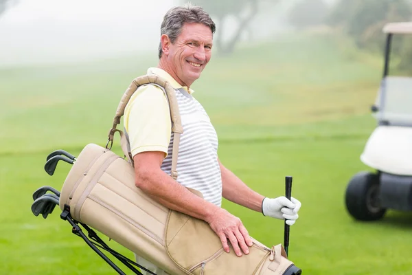 Glücklicher Golfer mit Golfbuggy im Rücken — Stockfoto