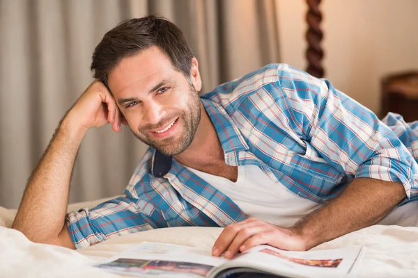 Hombre relajante en cama lectura revista —  Fotos de Stock