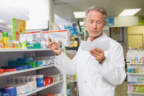 Concentrated pharmacist reading prescription — Stock Photo, Image