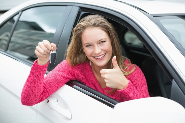 Young woman smiling and holding key — Stock Photo, Image