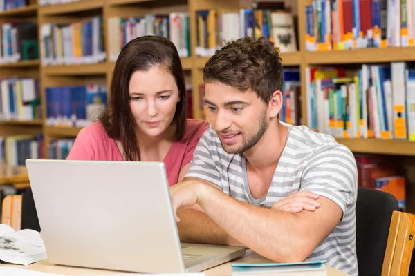 College students using laptop in library — Stock Photo, Image