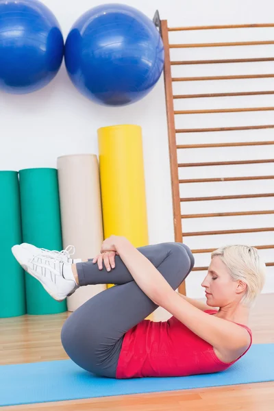 Mulher loira trabalhando no tapete de exercício — Fotografia de Stock