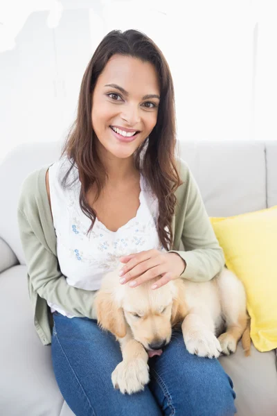 Mulher bonita com filhote de cachorro no sofá — Fotografia de Stock