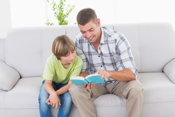 Vater liest Geschichte für Jungen auf Sofa — Stockfoto