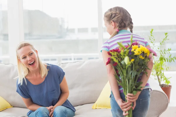 Madre guardando ragazza nascondendo bouquet — Foto Stock