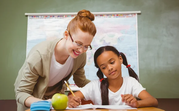 Enseignant aidant petite fille avec des devoirs en classe — Photo