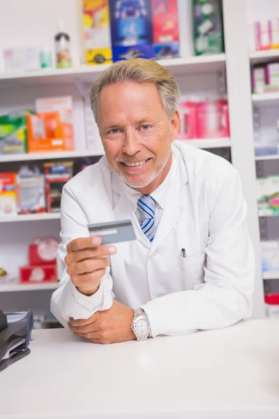 Smiling senior pharmacist holding credit card — Stock Photo, Image