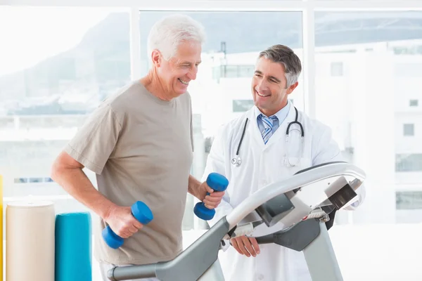 Senior man on treadmill with therapist — Stock Photo, Image