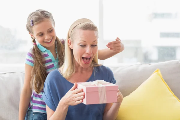 Girl surprising her mother with gift — Stock Photo, Image