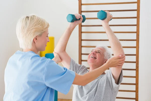 Senior man working out with his therapist — Stock Photo, Image