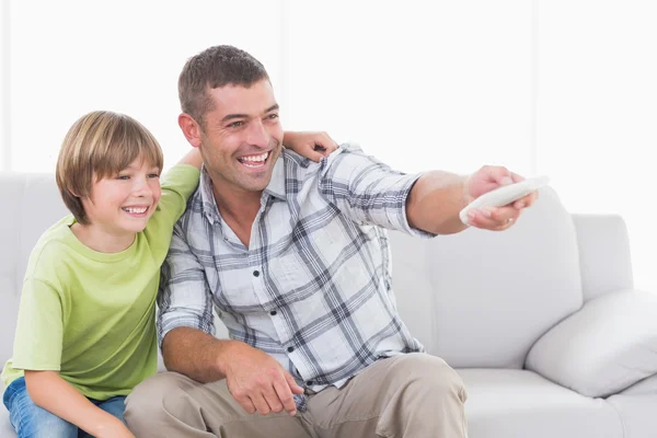 Feliz pai e filho usando controle remoto — Fotografia de Stock