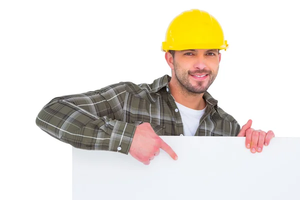 Handyman sosteniendo y apuntando al tablero en blanco — Foto de Stock