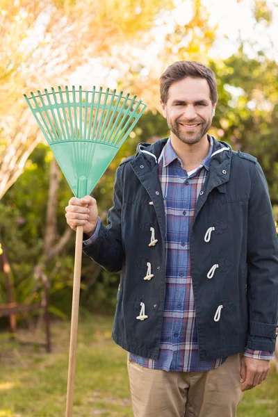 Handsome man smiling in his garden — Stock Photo, Image