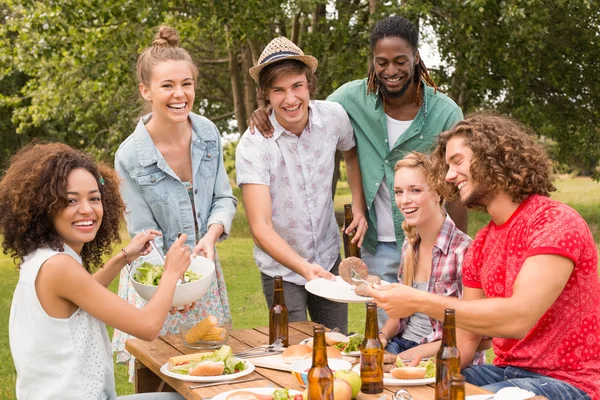 Amigos felices en el parque almorzando — Foto de Stock