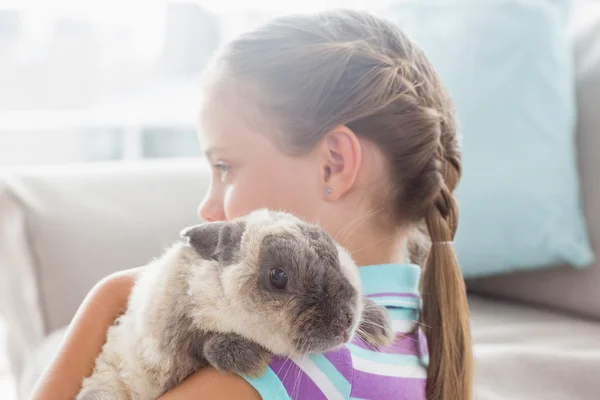 Ragazza che tiene il coniglio a casa — Foto Stock