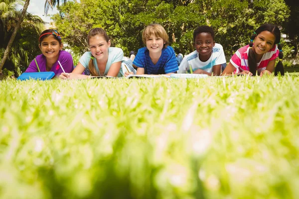 Niños haciendo deberes en el parque — Foto de Stock