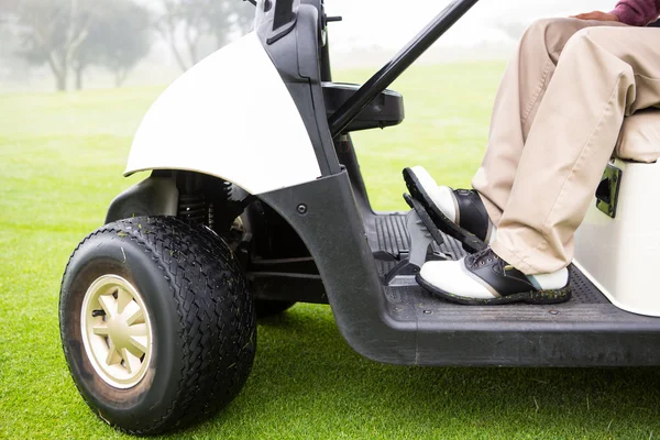 Гольфист за рулем своей гольф-коляски — стоковое фото