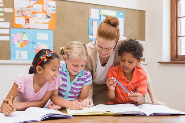 Lehrer und Schüler arbeiten gemeinsam am Schreibtisch — Stockfoto