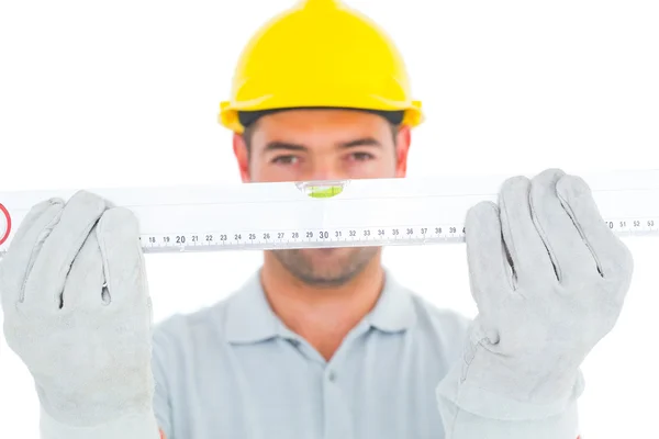 Handyman holding spirit level — Stock Photo, Image