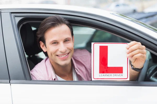 Motorista sorrindo e segurando l placa — Fotografia de Stock