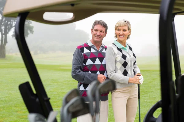 Счастливая пара гольфистов улыбается — стоковое фото