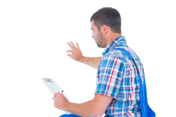 Handyman analisando enquanto segurando a área de transferência — Fotografia de Stock