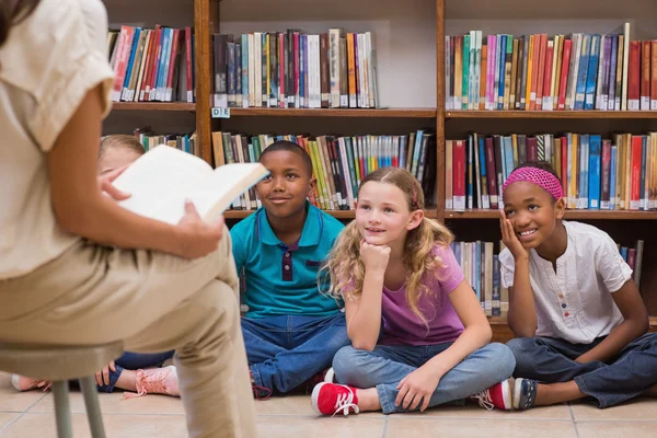 Cute pupils and teacher having class in library — Stock Photo, Image