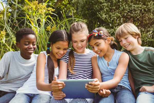 Barn som använder digital tablet på park — Stockfoto