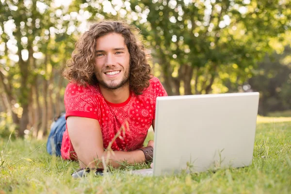 Knappe hipster met laptop in het park — Stockfoto