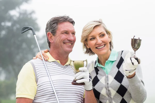 Happy golfing couple with trophy — Stock Photo, Image