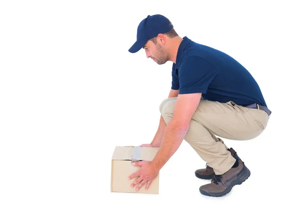 Delivery man picking cardboard box — Stock Photo, Image