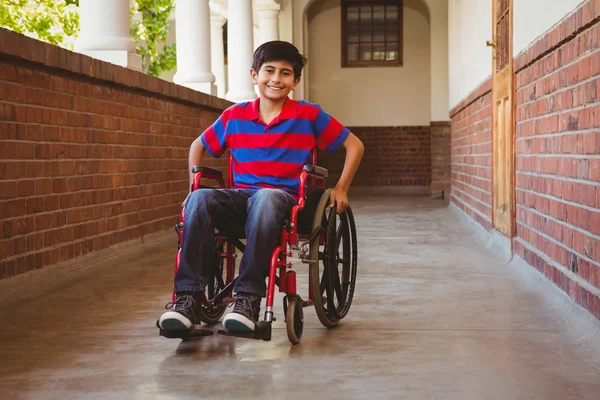 Ragazzo seduto in sedia a rotelle nel corridoio della scuola — Foto Stock