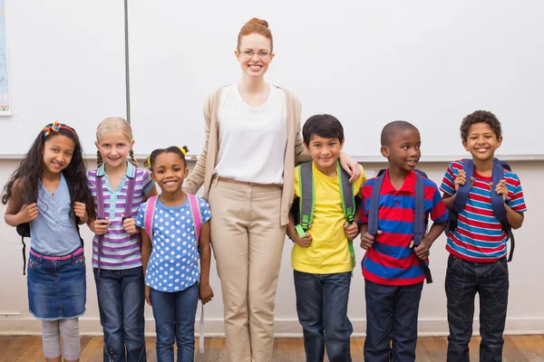 Enseignant et élèves souriant à la caméra en classe — Photo